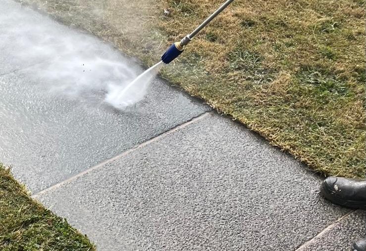 Pressure washing a paved driveway